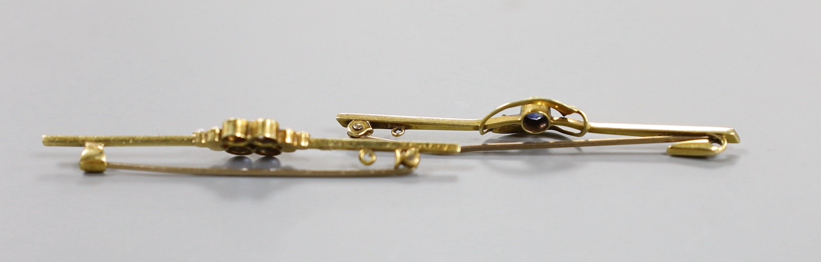 Two Edwardian 15ct bar brooches, one set with a sapphire, the other with sapphire and seed pearls 59mm, gross weight 5.8 grams.